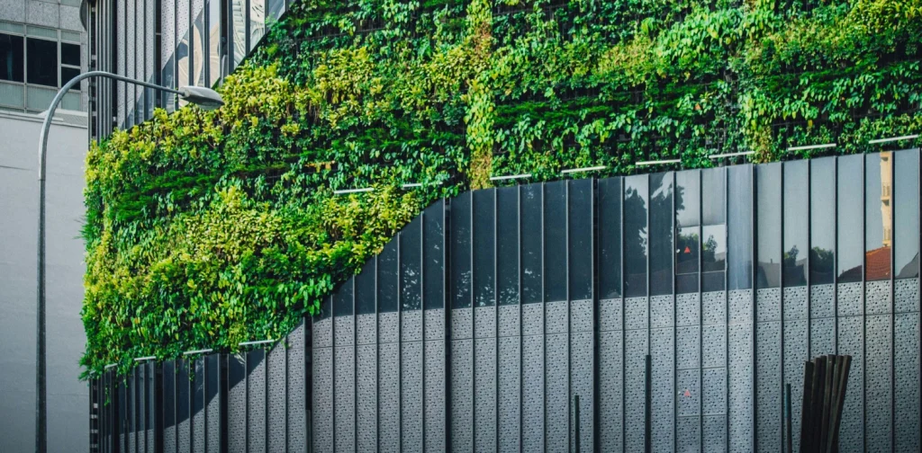 a photo of a glass building covered with plants