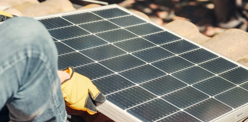 a hand installing a solar PV on the roof