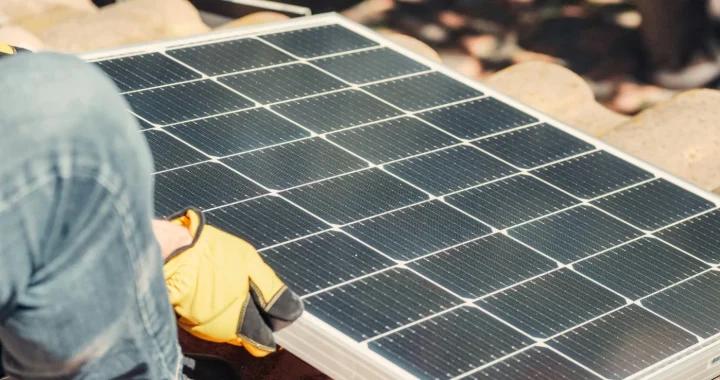 a hand installing a solar PV on the roof