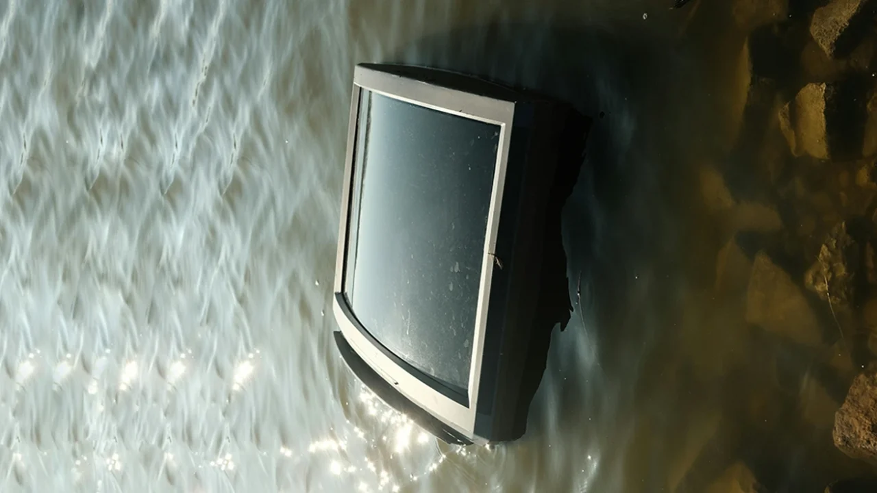 a television submerged in murky water