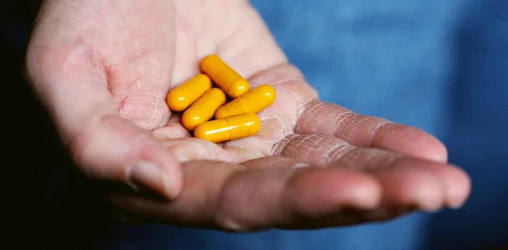 five yellow pills in someone’s palm