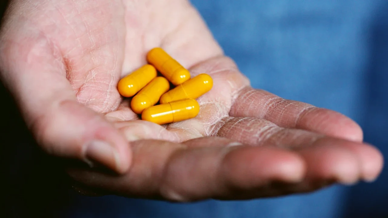 five yellow pills in someone’s palm