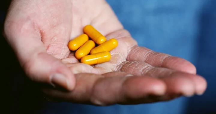 five yellow pills in someone’s palm