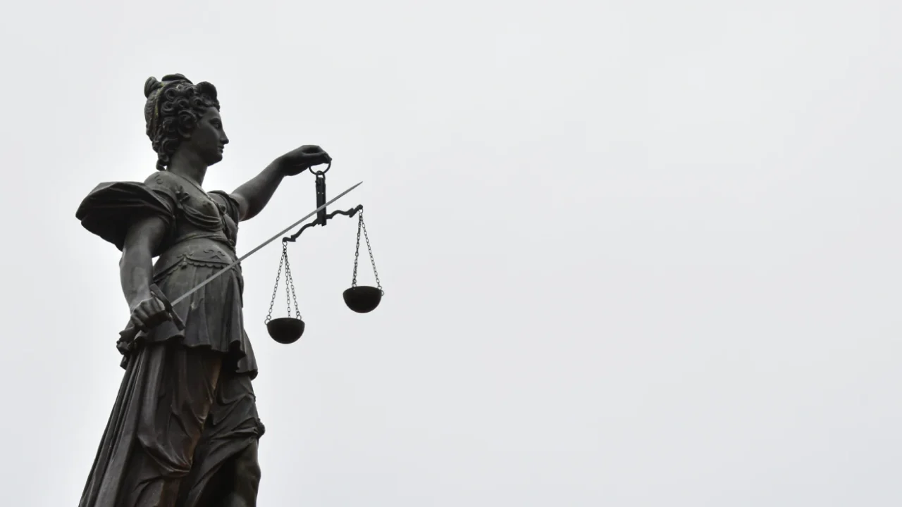 a statue of lady justice holding a scale of justice