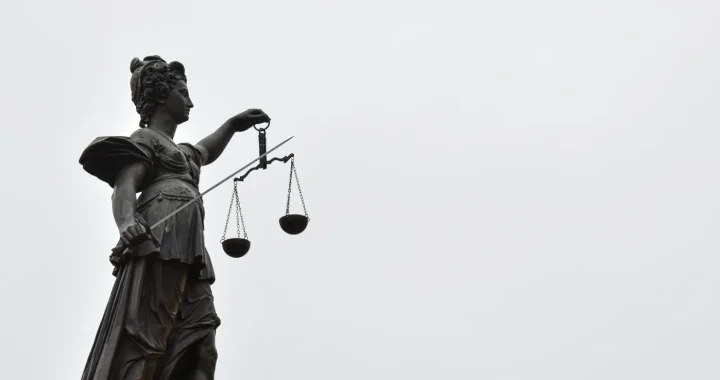 a statue of lady justice holding a scale of justice