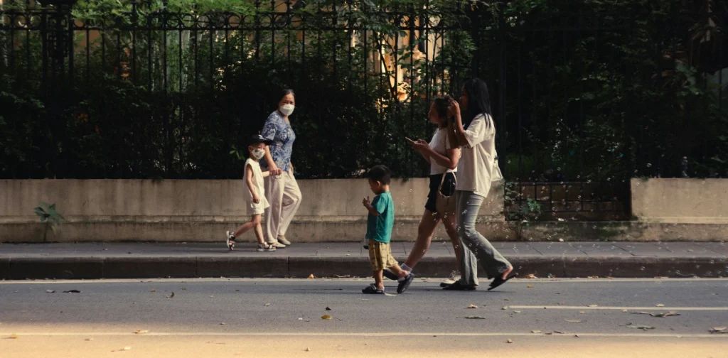 two sets of family with children walking the opposite ways on the road