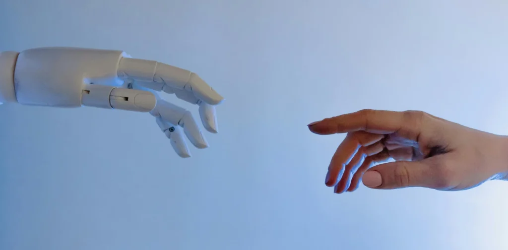 A human hand reaching toward a robotic hand.