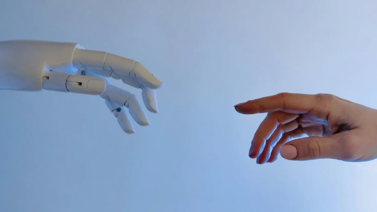 A human hand reaching toward a robotic hand.