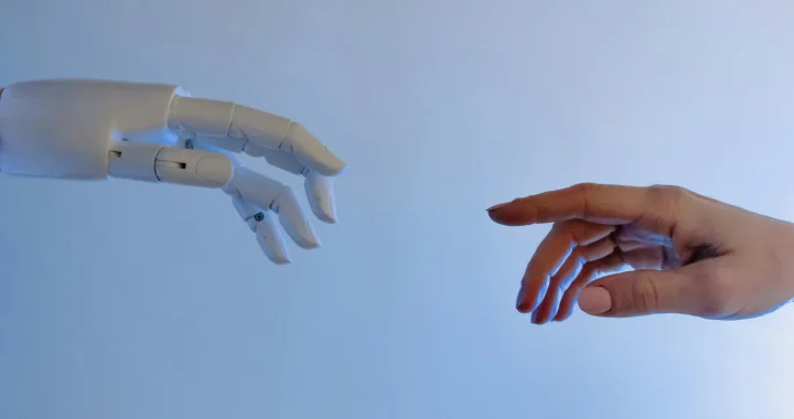 A human hand reaching toward a robotic hand.