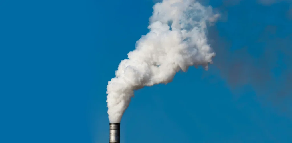 Thick white smoke coming out of factory chimney