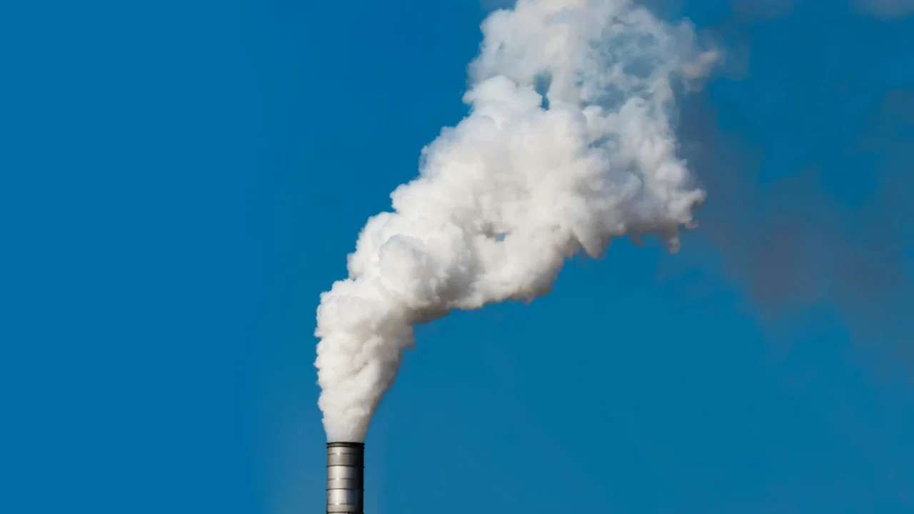 Thick white smoke coming out of factory chimney