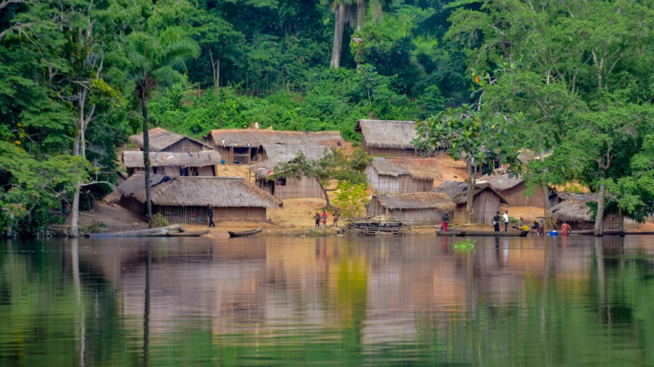 a village nestled between a basin and a forest