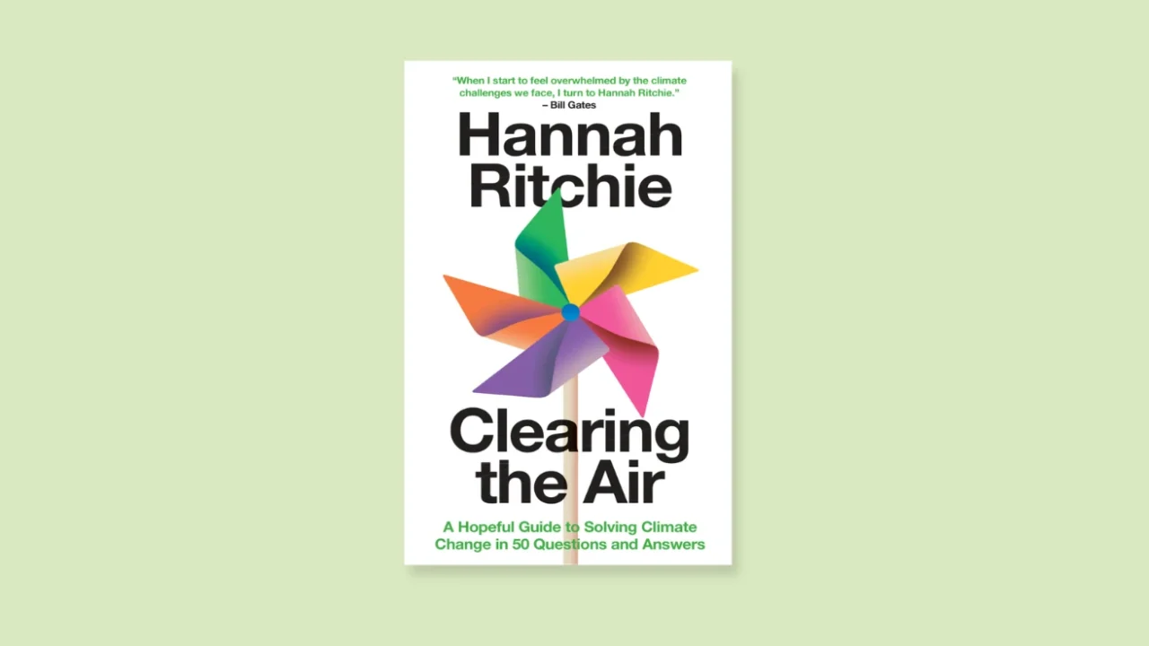 book cover with a colourful paper windmill of “Clearing the Air: A Hopeful Guide to Solving Climate Change in 50 Questions and Answers” by Hannah Ritchie.