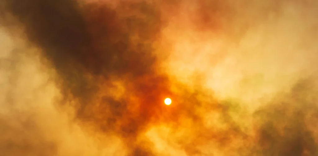 the sun shining through thick smoke