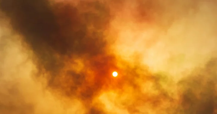 the sun shining through thick smoke